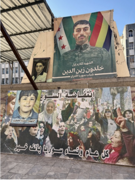   Sur la place al-Karame, dans la ville de Soueïda, qui était l’épicentre d’un mouvement de protestation pacifique contre le dictateur déchu Bachar al-Assad,  des photos des martyrs de la révolution syrienne (y compris du lieutenant Khaldoun Zain al-Din, qui avait fait défection de l’armée du régime Assad et rejoint les rangs de l’Armée syrienne libre à Daraa, à la mi-septembre 2011 (il est mort en 2013). Pancarte saluant le rôle des femmes dans la révolution (photo J. Daher, janv. 2025)